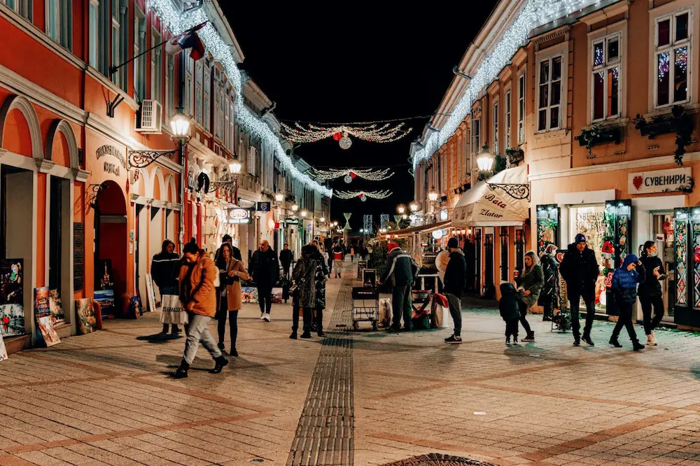 a street with people walking and shopping, novi sad